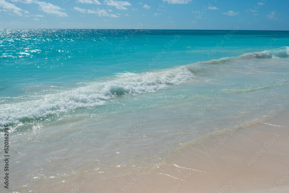 Caribbean Sea. A beautiful beach with white sand, a turquoise wave runs onto the shore. Relaxing landscape without people