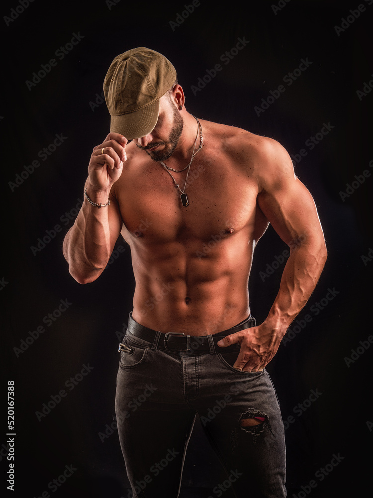 Shirtless muscular male bodybuilder in studio shot on black Shirtless muscular male bodybuilder in studio shot on black