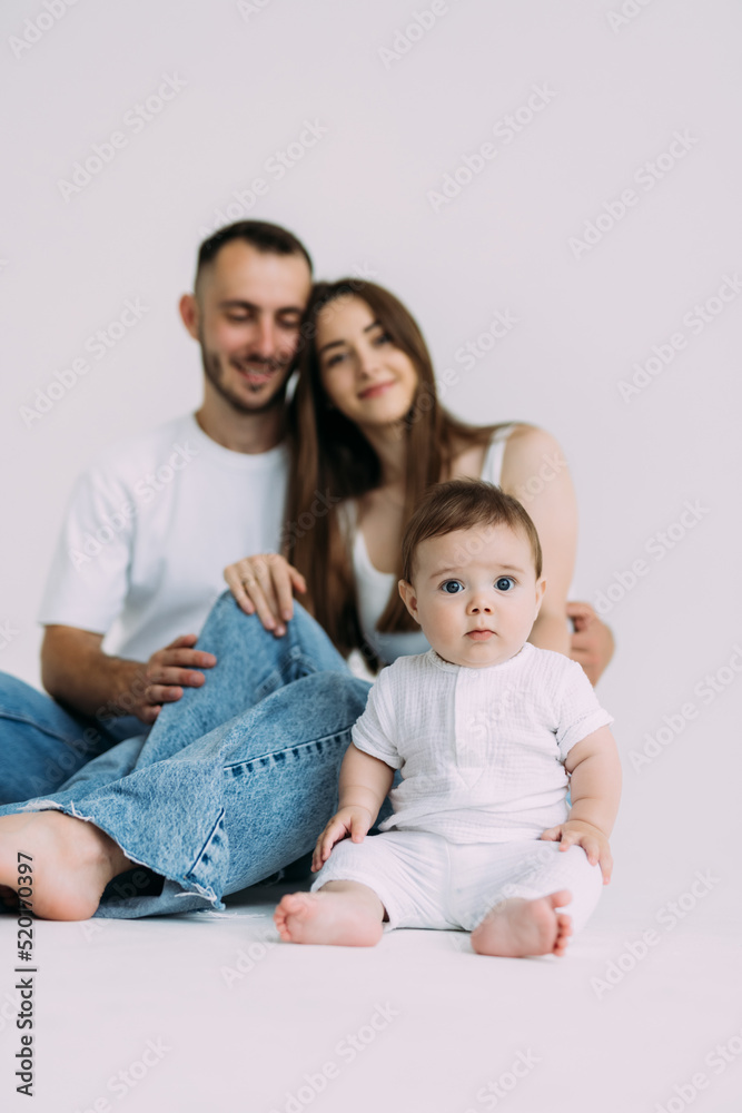 Young family: mother, father and baby son on white background