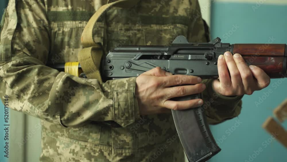 a soldier in camouflage uniform takes aim with his machine gun, preparing to fire close-up. fighting inside the building. firing at the enemy army. Kalashnikov shooting. combat clashes a soldier in camouflage uniform takes aim with his machine gun, preparing to fire close-up. fighting inside the building. firing at the enemy army. Kalashnikov shooting. combat clashes