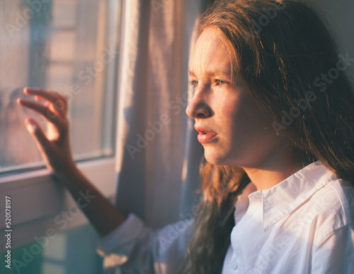 Sad teen near window