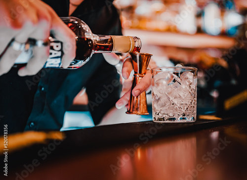 man bartender hand making negroni cocktail in bar