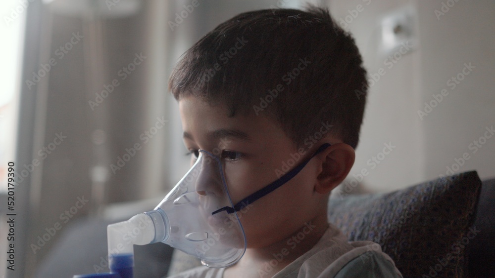 A kid breathing steam from an inhaler. Treatment of lung diseases A kid breathing steam from an inhaler. Treatment of lung diseases