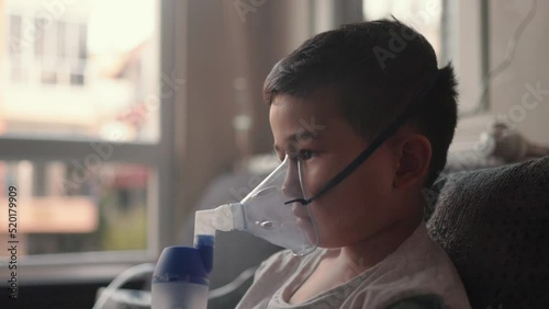 A kid breathing steam from an inhaler. Treatment of lung diseases
