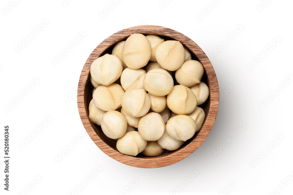 Macadamia nuts in wooden bowl isolated on white background, top view, flat lay. Macadamia nuts in wooden bowl isolated on white background, top view, flat lay.