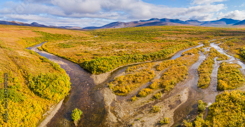 Aerial view over tundra landscape  in autumn colors with mountains and meandering rivers in the vicinity of Nome, Alaska photo