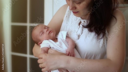 mother holding in her arms and caressing her newborn baby boy