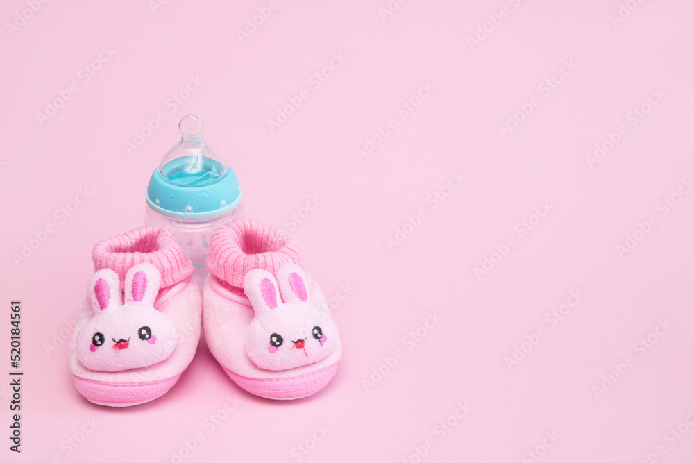 pink booties in the form of hares and a bottle on a pink background with copy space pink booties in the form of hares and a bottle on a pink background with copy space