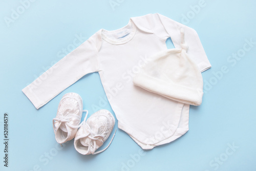 bodysuit for a newborn, cap and booties on a blue background photo