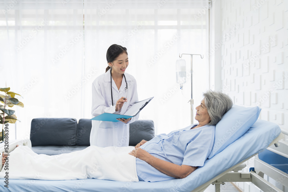 Fototapeta premium Nurse, elderly patient and hospital. Nurse discussing and writing note to seek advice with elderly asian woman on bed at the hospital. People and health care concept