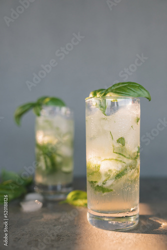Gin tonic with cucumber. Alcoholic long drink cocktail with dry gin, tonic, fresh cucumber, ice cubes and basil.