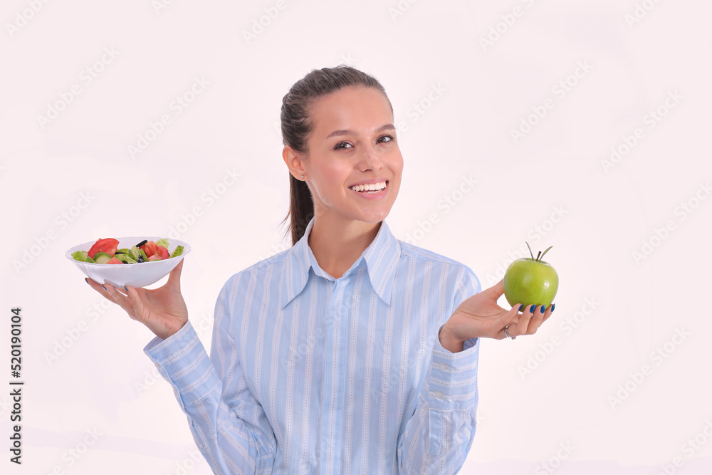 Portrait of a beautiful woman doctor holding a plate with fresh vegetables and green apple. Woman doctor Portrait of a beautiful woman doctor holding a plate with fresh vegetables and green apple. Woman doctor