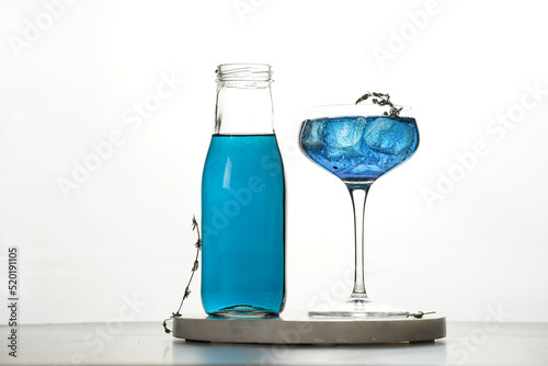 Dark blue drink in a vintage glass for sparkling wine - pea flower tea or blue curacao sirup cocktail, back lighting