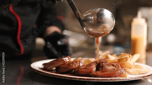Close-up Professional Chef at Restaurant Serves Dish Adding Final Ingredient by Hand. Cooking Food at Modern Home Cuisine. Delicious lamb meat