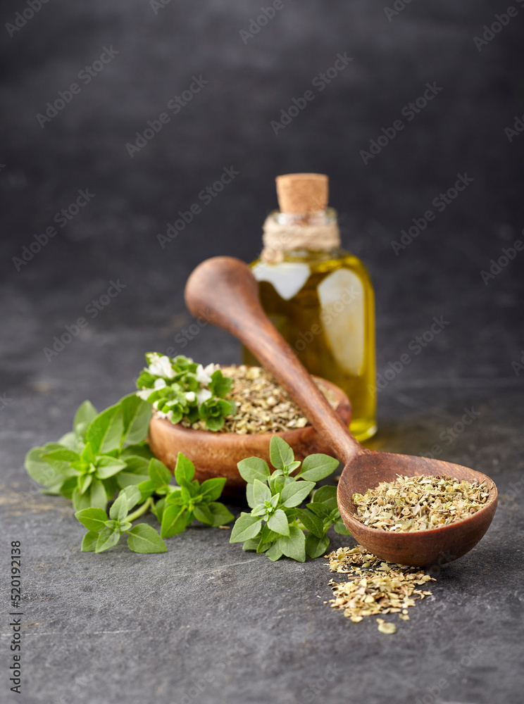 Basil fresh and dry in wooden bowl with olive oil on a black background. Basil fresh and dry in wooden bowl with olive oil on a black background.