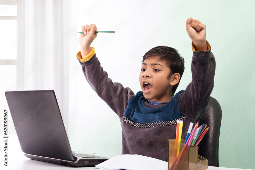 Boy using laptop and waving during video call while homeschooling Boy using laptop and waving during video call while homeschooling