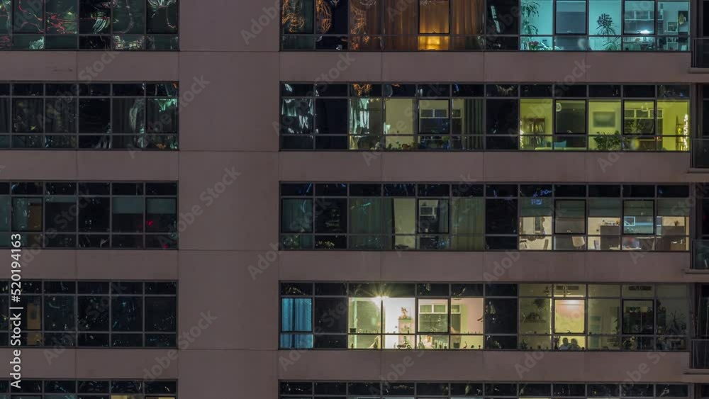 Windows lights in modern apartment buildings timelapse at night. Multi-level skyscrapers with illuminated rooms inside Windows lights in modern apartment buildings timelapse at night. Multi-level skyscrapers with illuminated rooms inside