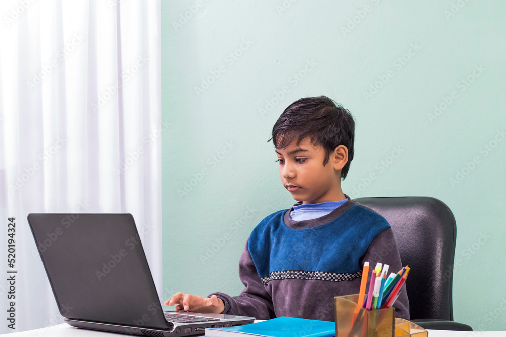 Little boys attending to online class from home. The school has been closed during coronavirus outbreak and the classes have moved to e-learning platform Little boys attending to online class from home. The school has been closed during coronavirus outbreak and the classes have moved to e-learning platform