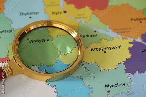 Fényképezés Golden magnifying glass above Vinnytsia region on map of Ukraine, closeup