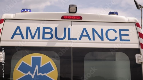 A white ambulance van on a wide city street, with warning lights and sirens, Metropolis Rescue Services vehicle, ambulance car responding in hazardous conditions, close up.