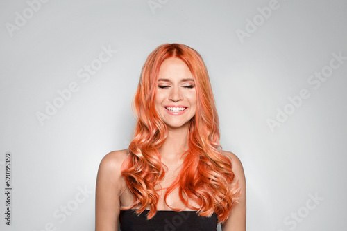 Beautiful woman with long orange hair on light background photo