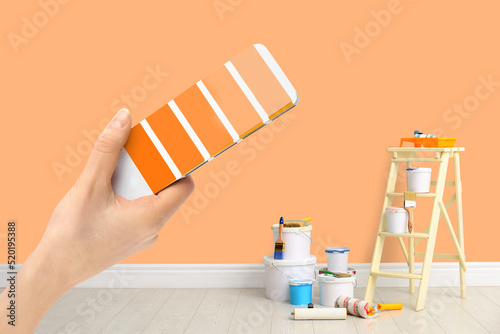 Obraz na plátně Decorator holding color palette samples in room with painted wall, closeup