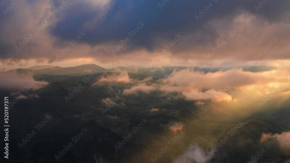 Low clouds over a highland plateau in the rays of sunset. Sunset on Bermamyt plateau North Caucasus, Karachay-Cherkessia, Russia. Low clouds over a highland plateau in the rays of sunset. Sunset on Bermamyt plateau North Caucasus, Karachay-Cherkessia, Russia.