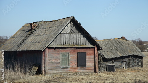 Abandoned old Russian wooden rural barn and house at spring day © Ilya