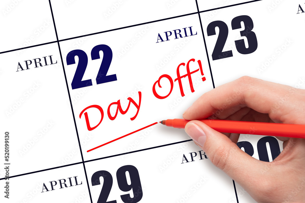 Hand writing text DAY OFF and drawing a line on calendar date 22 April. Vacation planning concept. Hand writing text DAY OFF and drawing a line on calendar date 22 April. Vacation planning concept.