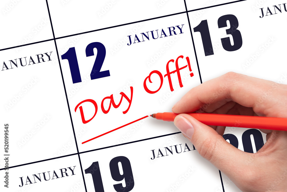 Hand writing text DAY OFF and drawing a line on calendar date 12 January. Vacation planning concept. Hand writing text DAY OFF and drawing a line on calendar date 12 January. Vacation planning concept.