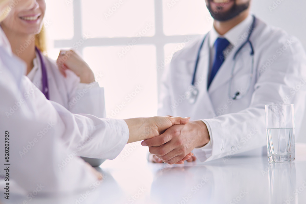 Doctor shaking hands with a male patient in the office Doctor shaking hands with a male patient in the office