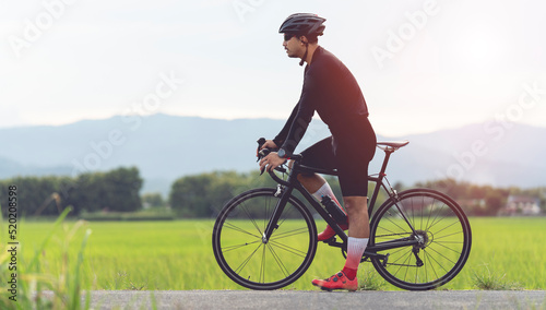 professional cyclist in cycling training suit against green nature blur background Healthy fitness and lifestyle concepts 