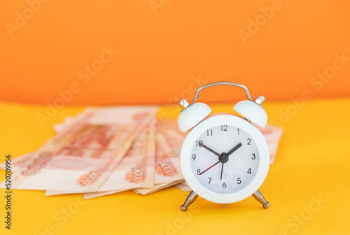 Time value of money concept.analog clock on russian ruble banknote, depicting receiving money today can be poised to increase the future value by investing and gaining interest over a period of time photo