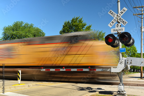 Vászonkép Freight train in motion speeding at crossing gate