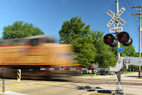 Freight train in motion speeding at crossing gate