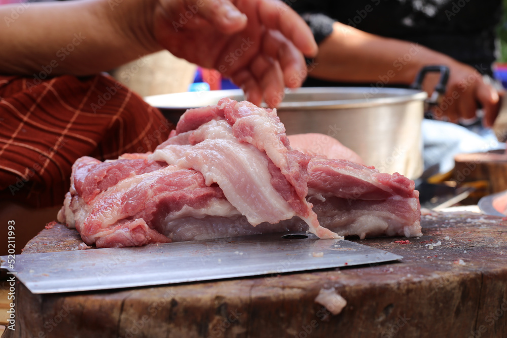 Raw pork chop on cutting board, pig shoulder butt meat cut out.