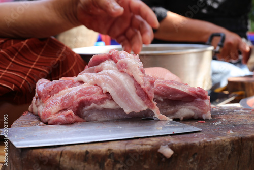 Raw pork chop on cutting board, pig shoulder butt meat cut out.
