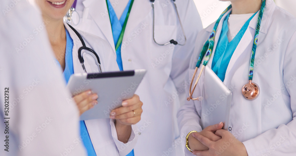 Doctor showing something in his tablet to his medical team Doctor showing something in his tablet to his medical team