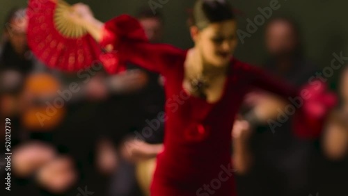 Beautiful stylish female artist dancing spanish style dance . Group of men playing on guitar and applauds to the dancer woman . Concept footage of spanish traditional culture . Waving cloth of skirt 