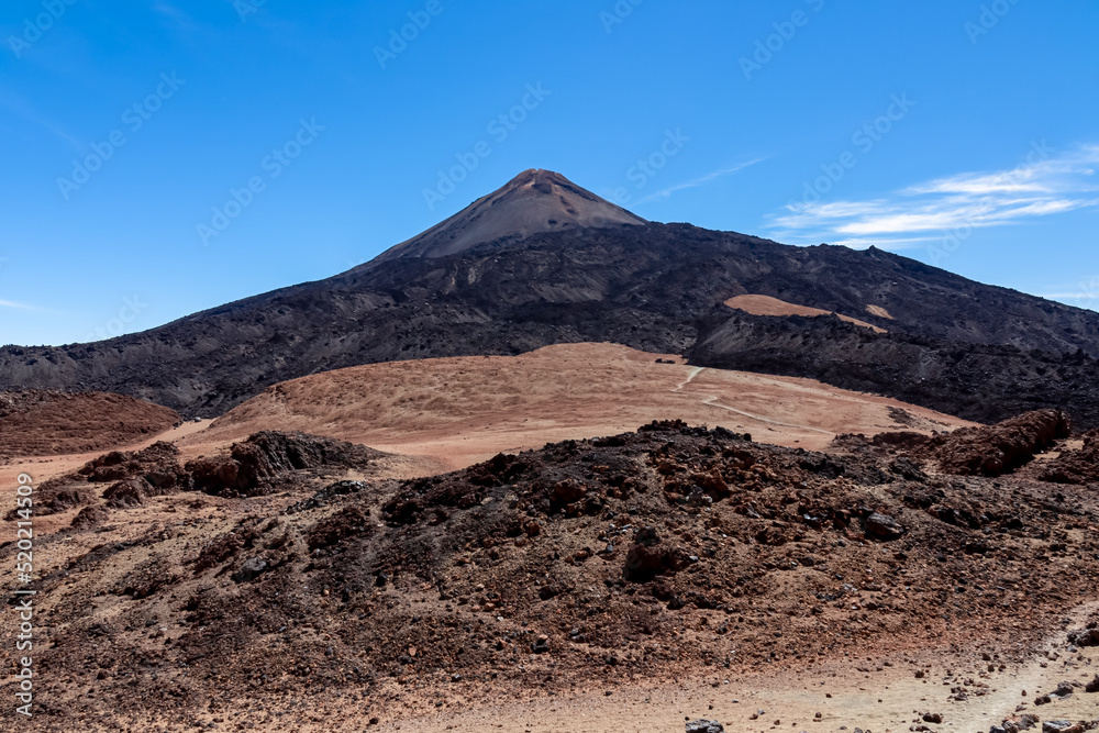 Hiking trail over volcanic desert terrain leading to summit of volcano Pico del Teide from Pico Viejo, Mount Teide National Park, Tenerife, Canary Islands, Spain, Europe. Solidified lava, ash, pumice