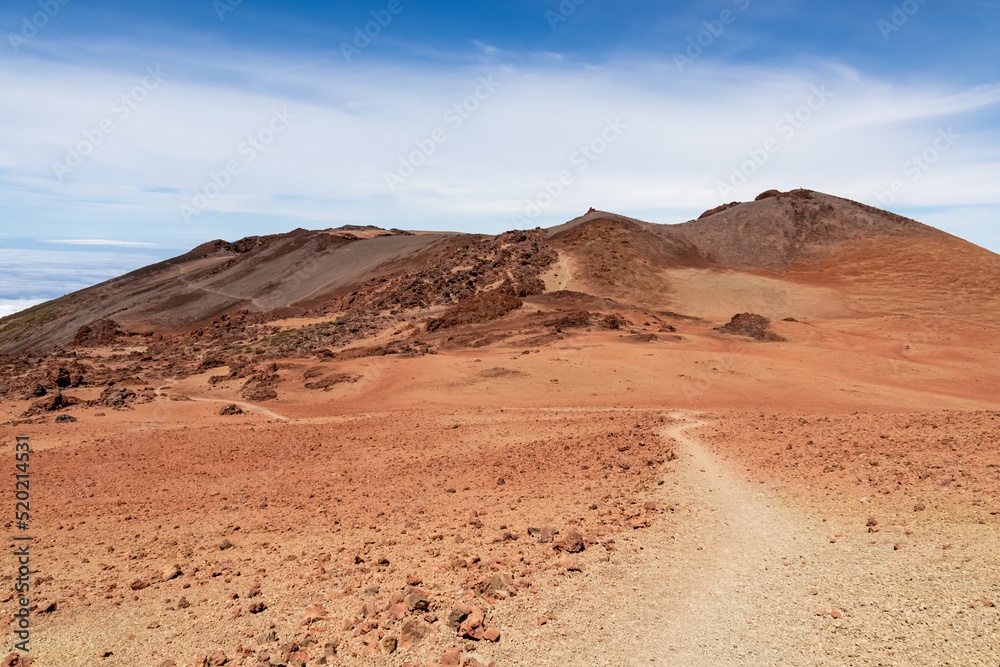 Hiking trail over volcanic desert terrain leading to summit of volcano Pico del Teide from Pico Viejo, Mount Teide National Park, Tenerife, Canary Islands, Spain, Europe. Solidified lava, ash, sand Hiking trail over volcanic desert terrain leading to summit of volcano Pico del Teide from Pico Viejo, Mount Teide National Park, Tenerife, Canary Islands, Spain, Europe. Solidified lava, ash, sand