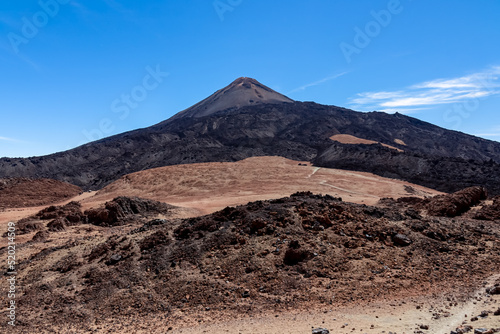 Hiking trail over volcanic desert terrain leading to summit of volcano Pico del Teide from Pico Viejo, Mount Teide National Park, Tenerife, Canary Islands, Spain, Europe. Solidified lava, ash, pumice