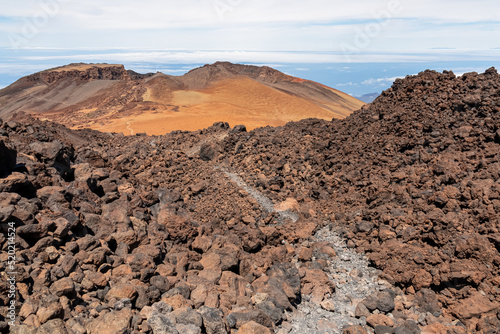 Panoramic view on crater of mountain Pico Viejo on hiking trail to volcano Pico del Teide, Mount Teide National Park, Tenerife, Canary Islands, Spain, Europe. Walking on barren volcanic desert terrain