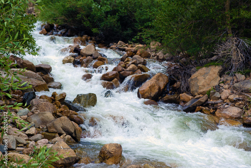 Fast moving river rushing over large granite boulders 