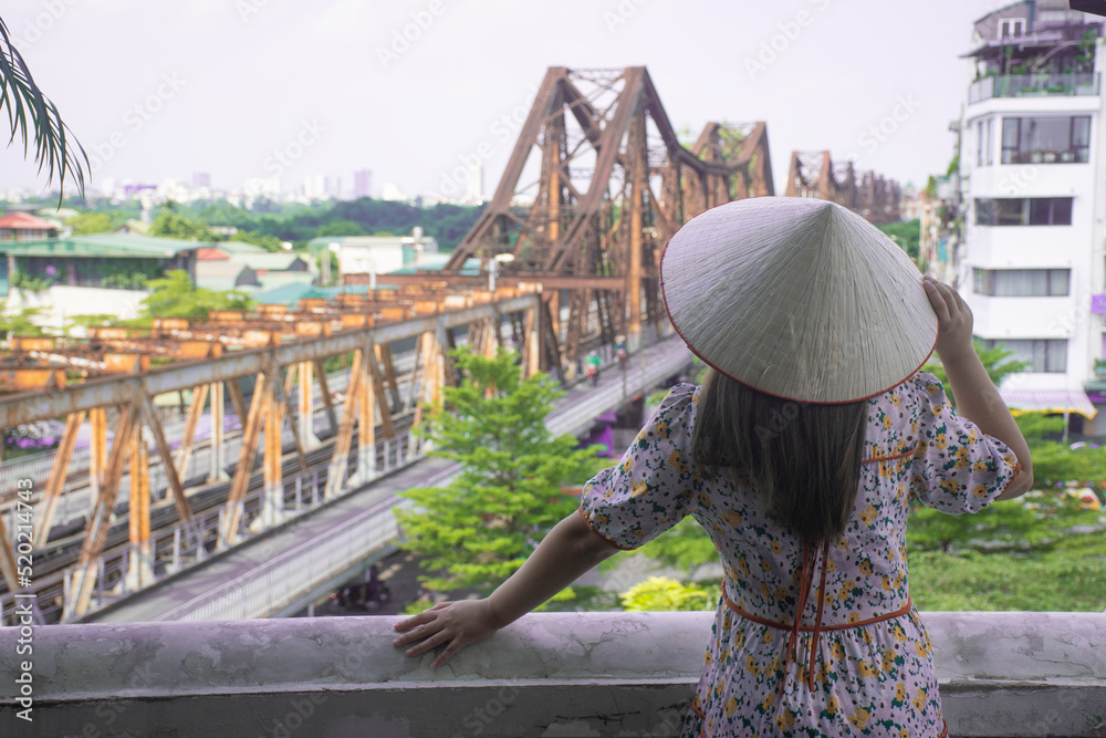 Woman traveller is sightseeing at Long Biên Bridge is a historic bridge across the Red River 