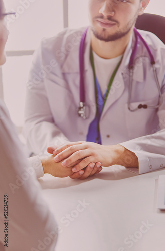 Close-up of stethoscope and paper on background of doctor and patient hands