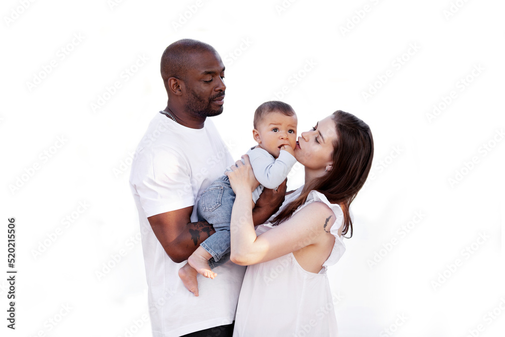 Happy multiracial family. Caucasian Mom and african american dad kiss small baby. Parents, Portrait of mother, father and child on hands isolated on white background