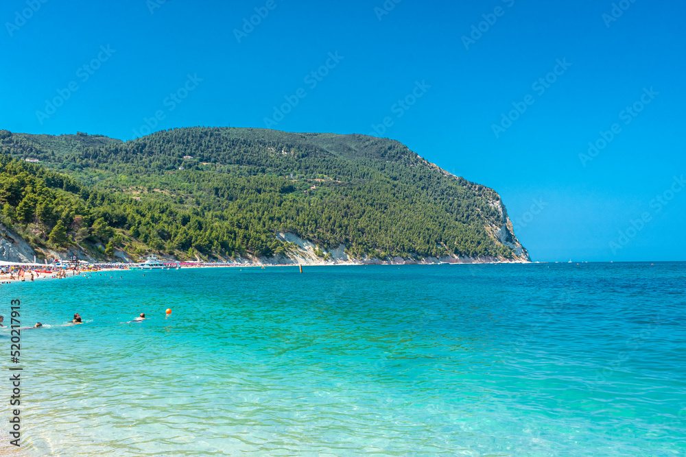 SIROLO, ITALY, 23 JULY 2021 Tourists on Urbani Beach down the Conero Mount in the Marche Region SIROLO, ITALY, 23 JULY 2021 Tourists on Urbani Beach down the Conero Mount in the Marche Region
