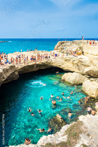 SALENTO, ITALY, 11 AUGUST 2021 People diving in the crystal clear water of the Grotta della Poesia (Poetry Cave)