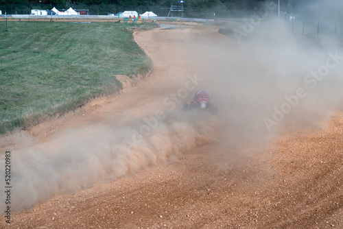 buggies on the autocross track, skidding, dust and dirt flying under the tires